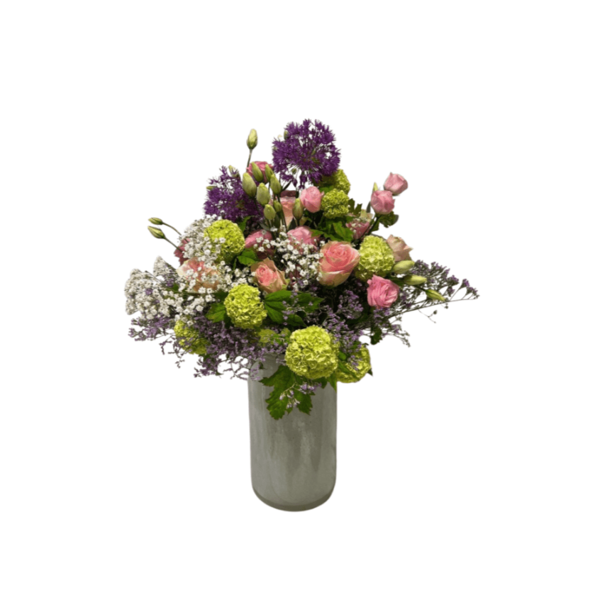 Der Sommerball von florali ist eine hohe Glasvase gefüllt mit rosa Rosen, violetten und weißen Blumen, grünen Hortensien und üppigem Grün – wunderschön arrangiert für ein lebendiges Schauspiel.