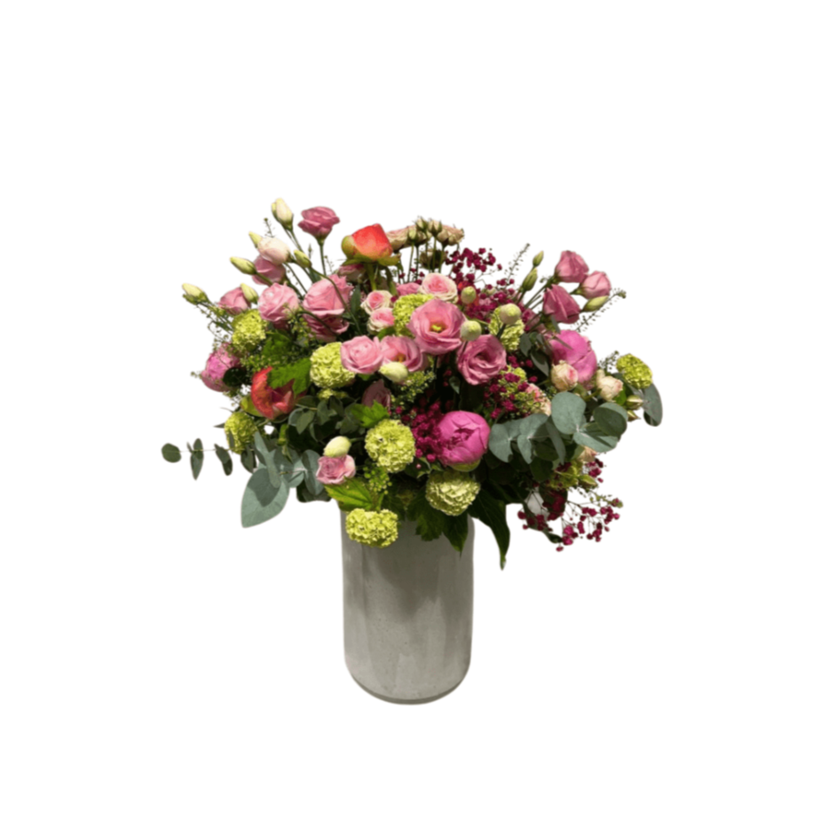 Der florali Sommertanz ist ein großer Strauß aus rosa, roten und grünen Pfingstrosen und üppigem Grün, elegant arrangiert in einer hohen weißen Vase vor einem schlichten weißen Hintergrund.