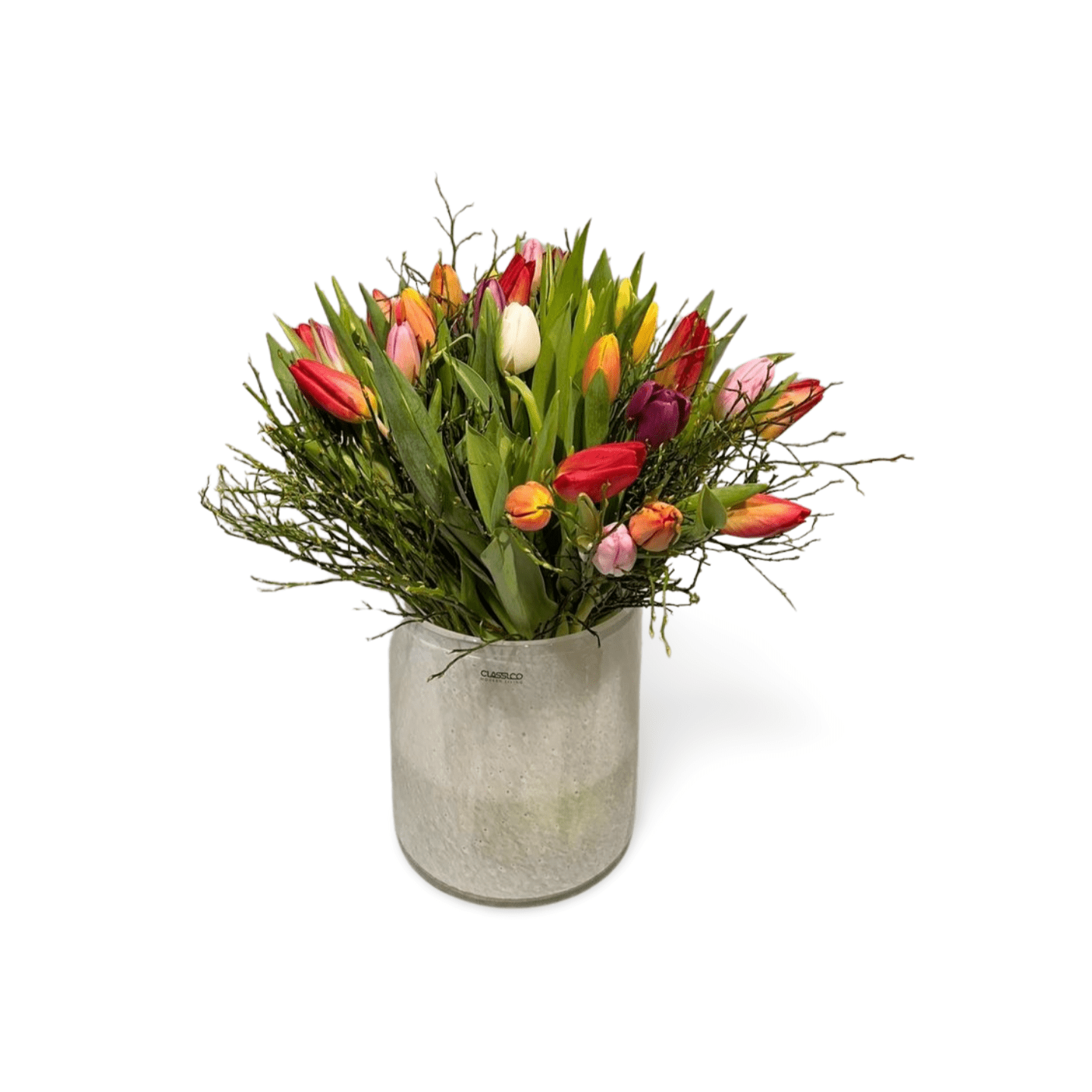 Der Tulpenstrauß „Tulip Rainbow“ von florali präsentiert bunte Tulpen in Rot, Gelb, Orange, Pink und Weiß mit Eukalyptus und Zweigen in einer Silbervase – ein frischer Farbakzent für Ihr Zuhause.