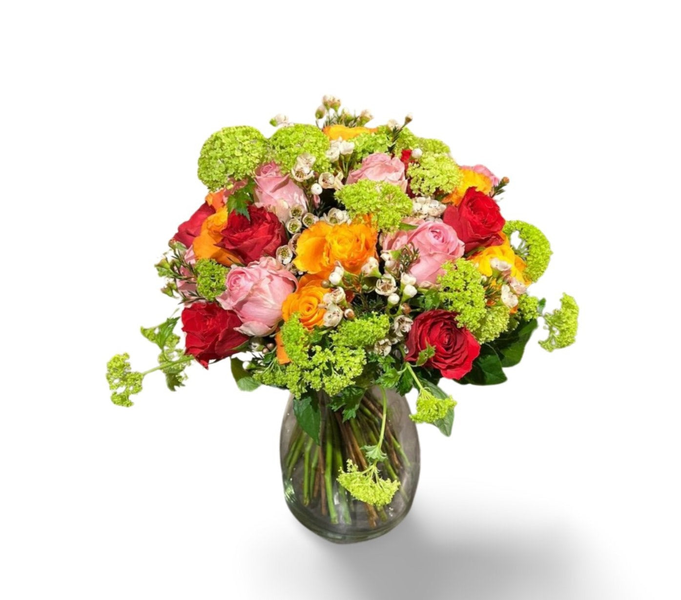 Das florali „Golden Sunrise“ ist eine klare Glasvase mit einem lebendigen Strauß aus roten, rosa und gelben Rosen, weißen Akzentblüten, frischem Eukalyptus und üppigem Grün, wunderschön arrangiert vor einem weißen Hintergrund.