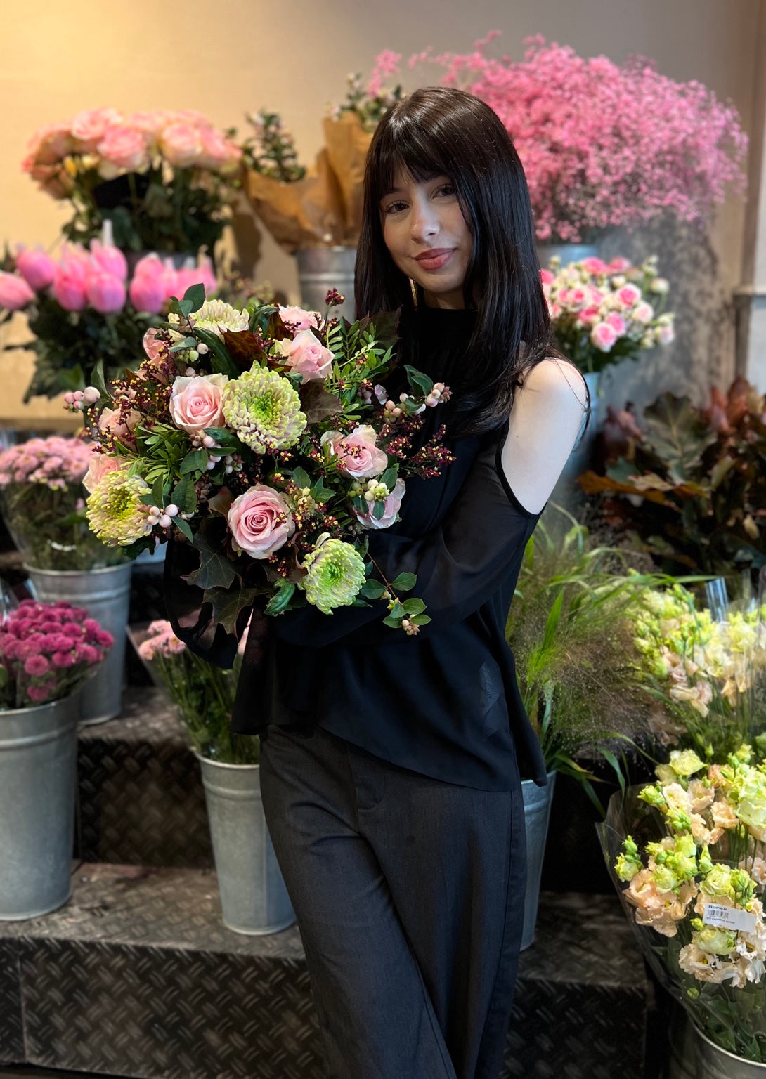 Floristin mit rosa Rosen und grünen Chrysanthemen im florali Blumengeschäft