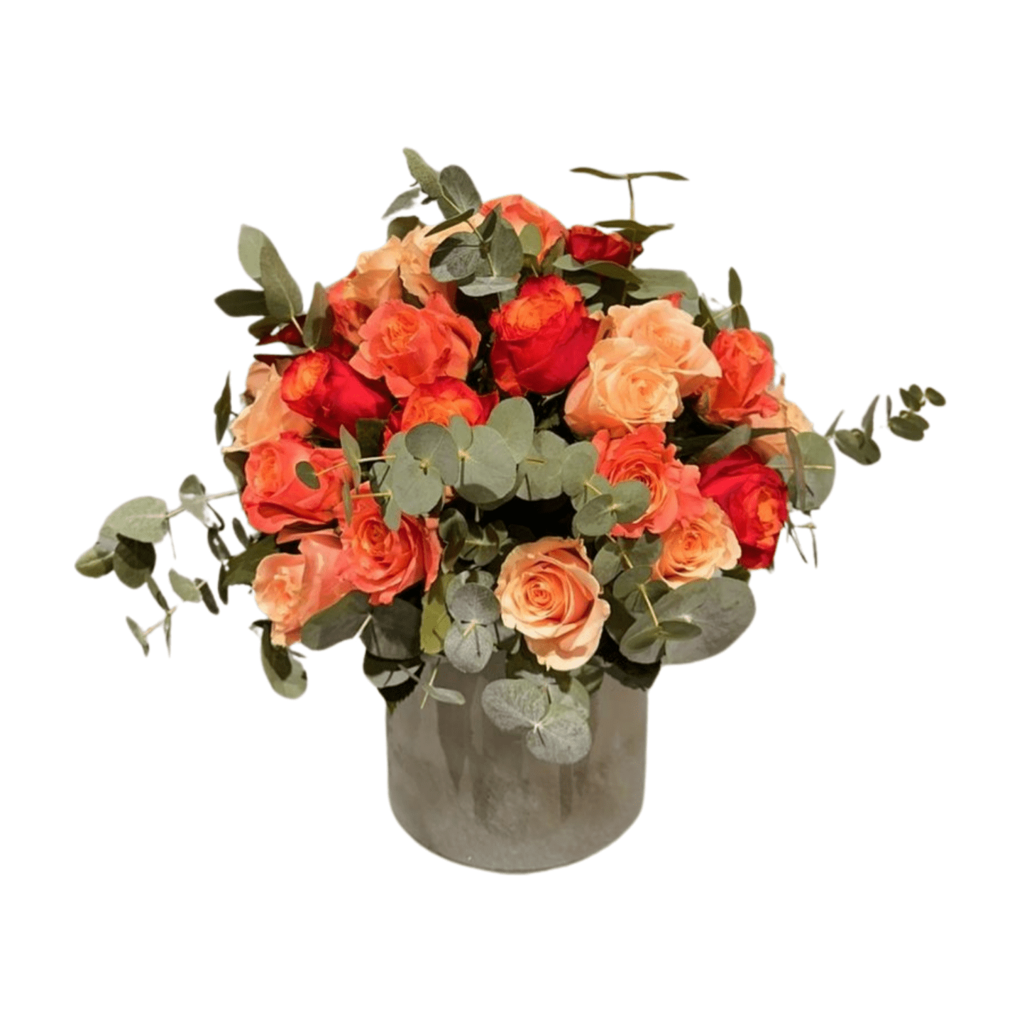 Der Blumenstrauß „Florali Little K“ besteht aus leuchtend roten und pfirsichfarbenen Rosen, akzentuiert mit üppigem Eukalyptusgrün und elegant arrangiert in einer runden, klaren Glasvase.