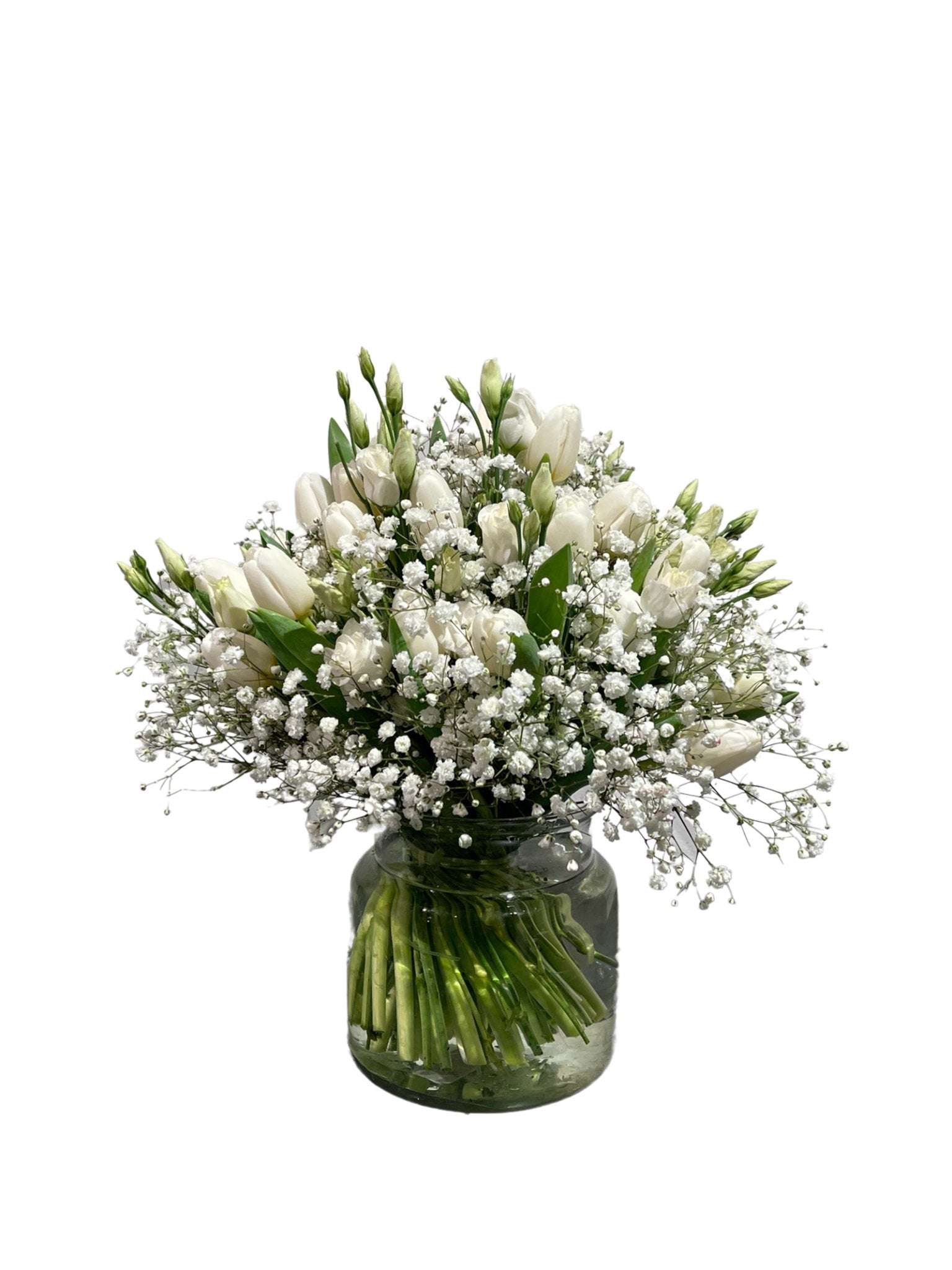 Das florale „Antartic Dream“ besteht aus einem Glasgefäß mit einem Strauß weißer Tulpen und Schleierkraut, deren grüne Stiele unter Wasser sichtbar sind, vor einem schlichten weißen Hintergrund.