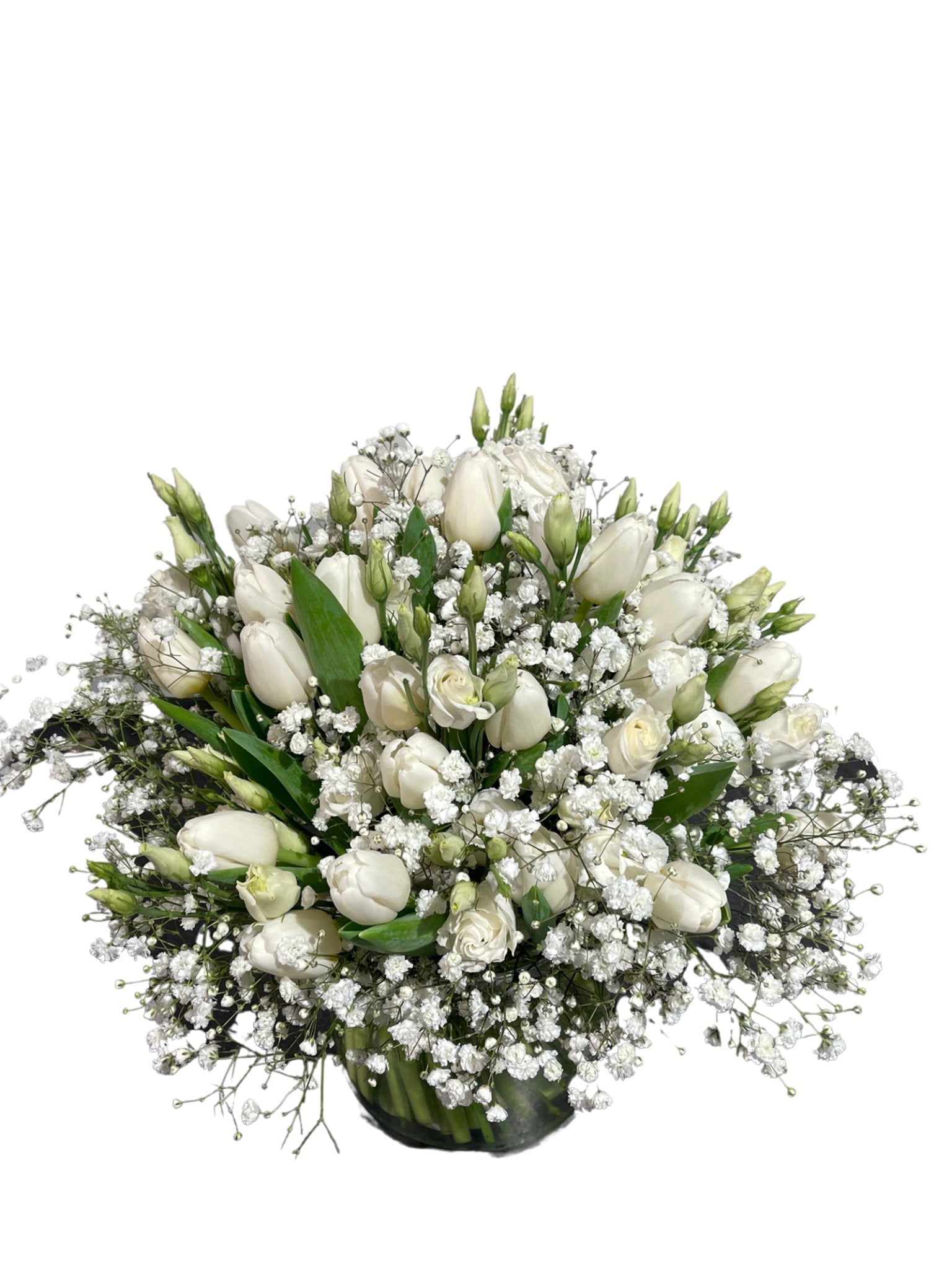Der Antartic Dream von florali besteht aus einem atemberaubenden Strauß weißer Tulpen, Rosen und Schleierkraut mit üppigem Grün, kunstvoll arrangiert in einer klaren Glasvase.